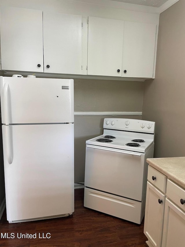 kitchen with white cabinets, dark hardwood / wood-style flooring, and white appliances