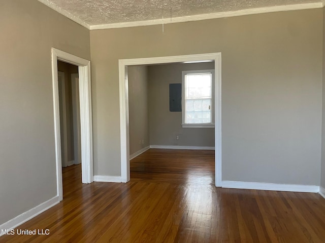 spare room with a textured ceiling, electric panel, crown molding, and dark hardwood / wood-style floors