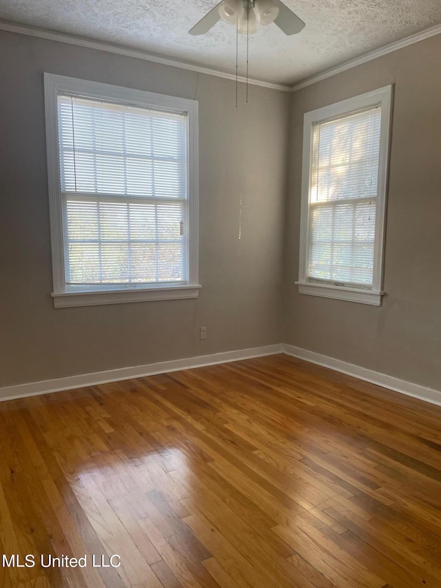 spare room featuring wood-type flooring, a textured ceiling, crown molding, and ceiling fan