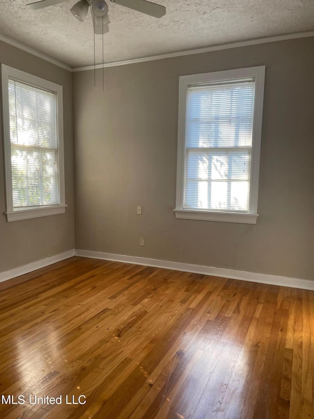 unfurnished room featuring ceiling fan, a textured ceiling, ornamental molding, and hardwood / wood-style floors