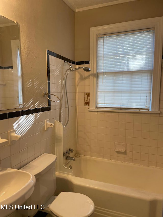 full bathroom featuring toilet, tiled shower / bath, and sink