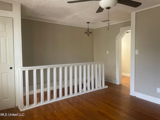 spare room featuring ceiling fan, wood-type flooring, a textured ceiling, and ornamental molding