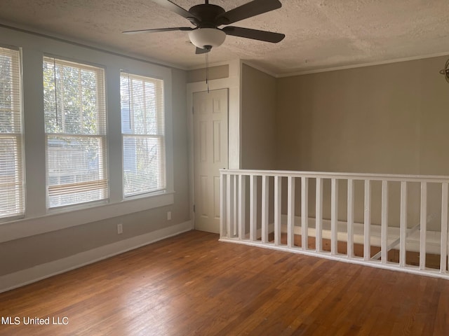 unfurnished room featuring ceiling fan, wood-type flooring, crown molding, and a textured ceiling