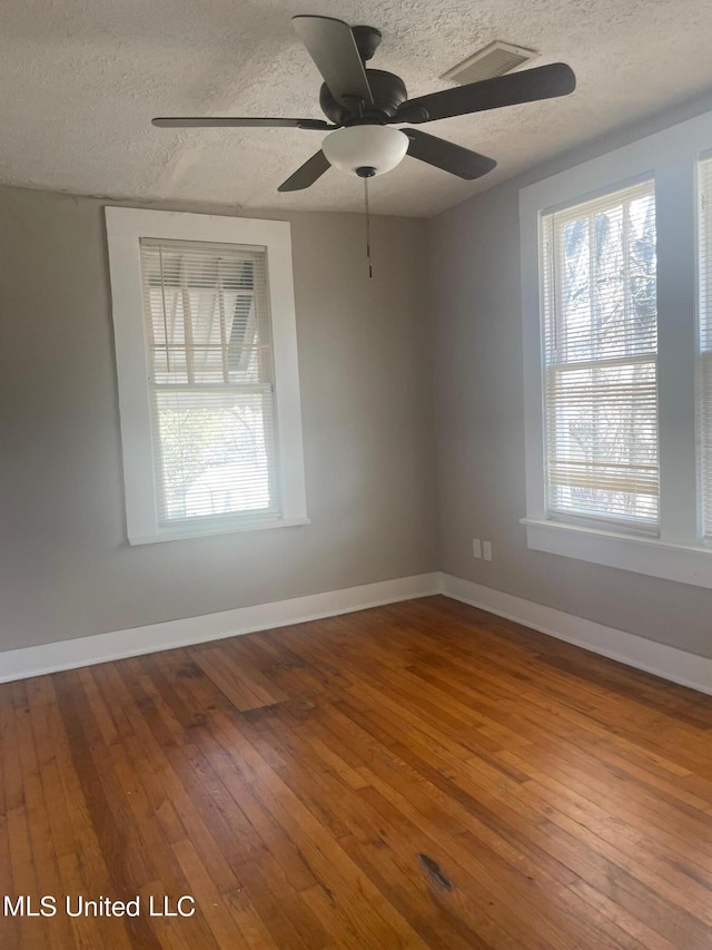 unfurnished room featuring a textured ceiling, ceiling fan, and hardwood / wood-style flooring