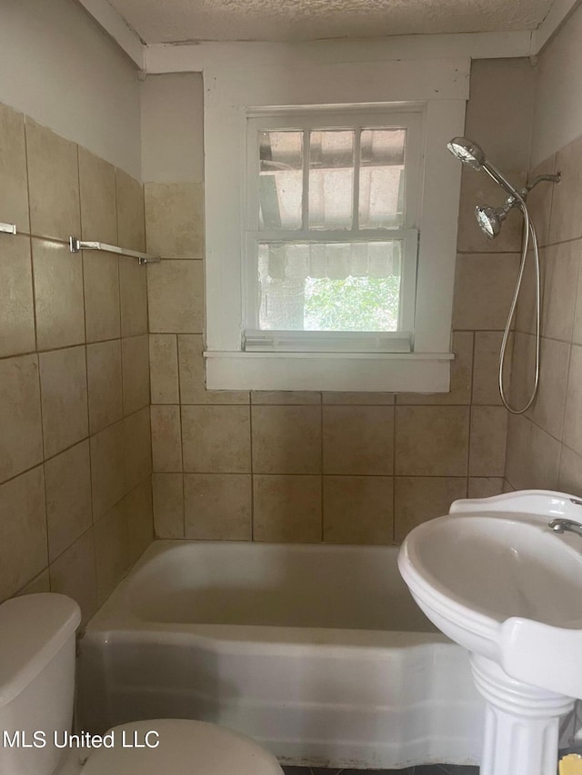 bathroom featuring toilet and tiled shower / bath combo