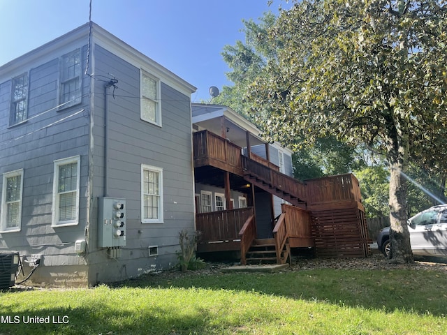 back of house with central AC and a lawn