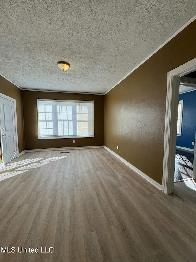 interior space with a wealth of natural light, ornamental molding, and hardwood / wood-style flooring