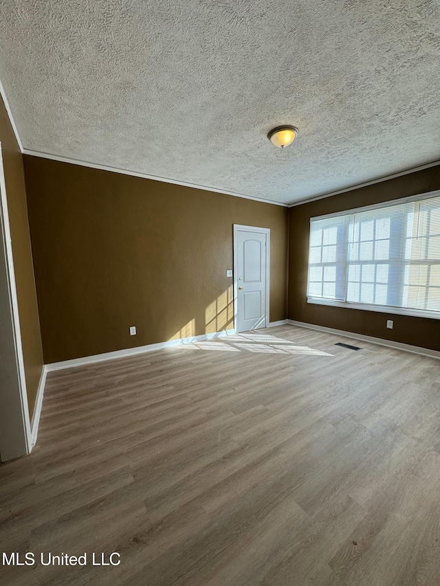 unfurnished bedroom featuring wood-type flooring and crown molding