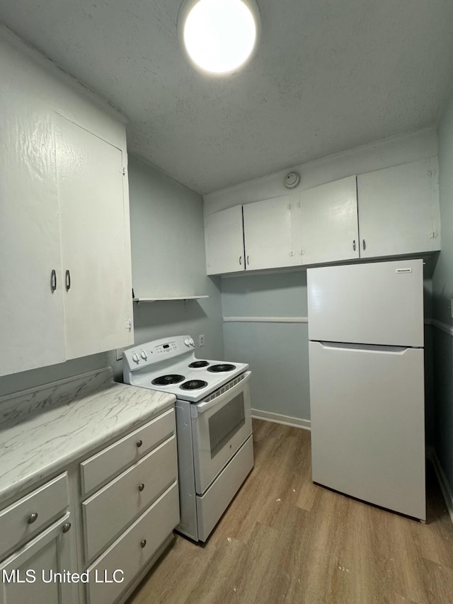 kitchen featuring light hardwood / wood-style flooring, white cabinets, and white appliances