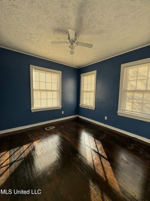 empty room with ceiling fan, wood-type flooring, and a textured ceiling