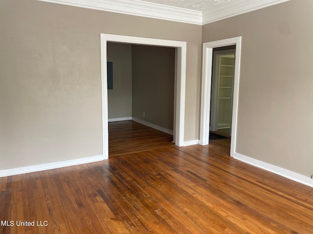 empty room featuring dark hardwood / wood-style floors and ornamental molding