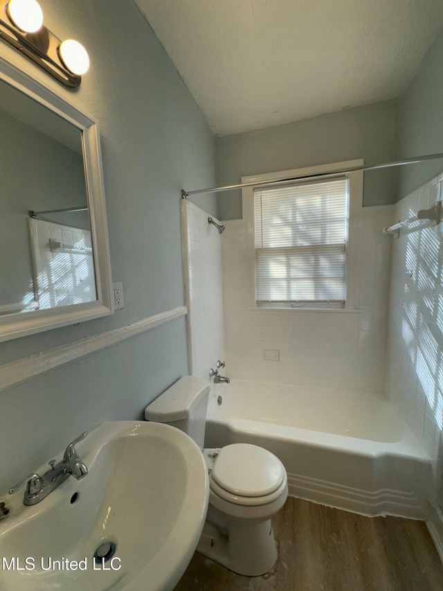 full bathroom with toilet, tiled shower / bath, sink, and hardwood / wood-style flooring