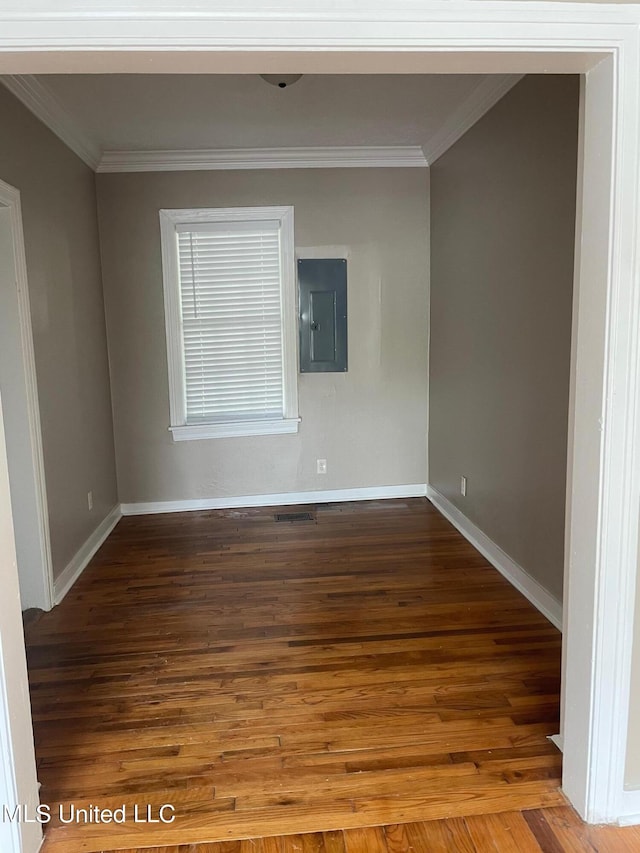 spare room featuring hardwood / wood-style flooring, crown molding, and electric panel