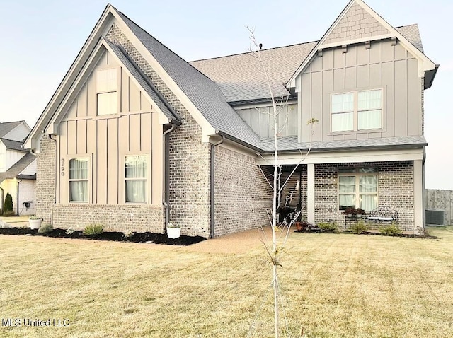 back of property with a yard and central AC unit