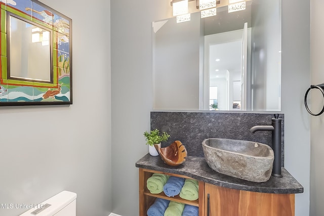 bathroom featuring toilet, tasteful backsplash, and vanity