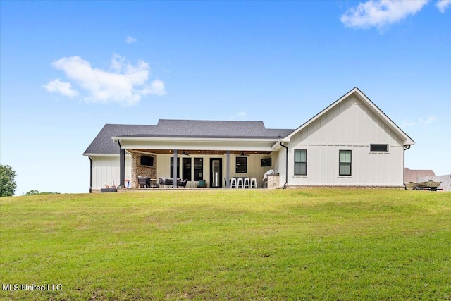 back of house with a lawn, ceiling fan, a patio area, and board and batten siding