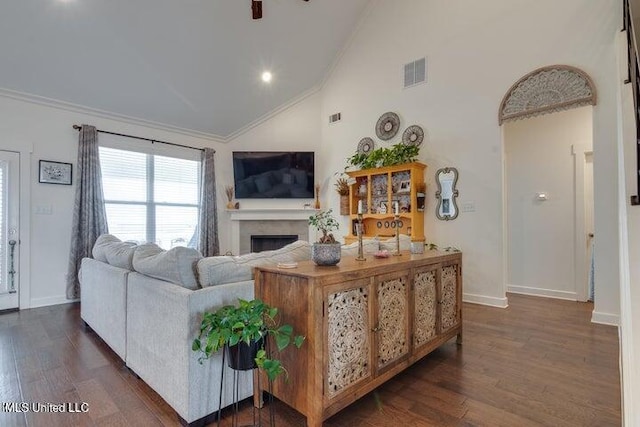 living area featuring visible vents, ornamental molding, dark wood-style floors, a fireplace, and baseboards