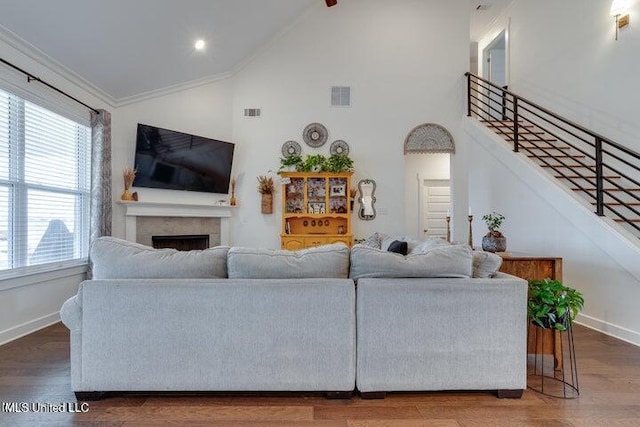 living room featuring visible vents, baseboards, wood finished floors, and a fireplace