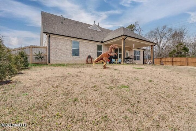 rear view of house with brick siding and fence