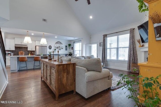 living room with visible vents, high vaulted ceiling, ornamental molding, dark wood-style floors, and baseboards