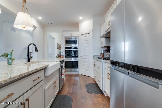 kitchen featuring under cabinet range hood, dark wood-style floors, white cabinets, stainless steel appliances, and a sink