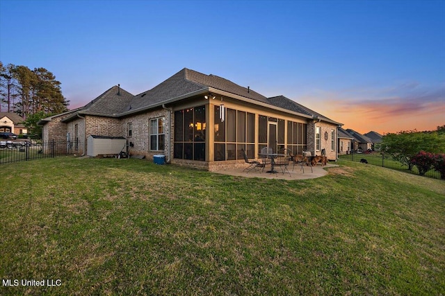 136 Mullherrin Dr, Madison, MS 39110 - back of property at dusk with a yard, a patio area, a fenced backyard, and a sunroom