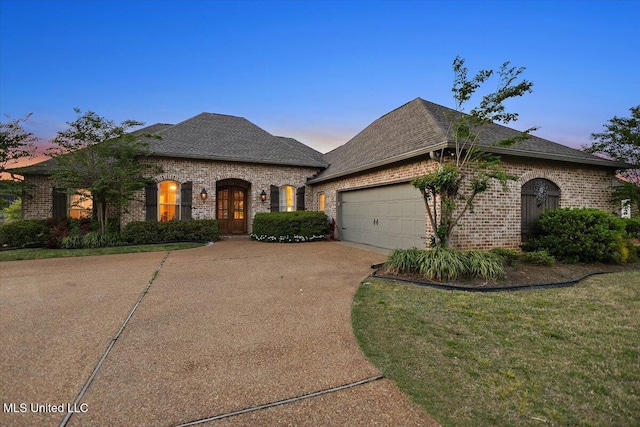 136 Mullherrin Dr, Madison, MS 39110 - french country inspired facade featuring concrete driveway, french doors, a front lawn, an attached garage, and brick siding