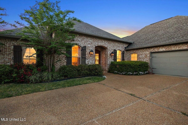 136 Mullherrin Dr, Madison, MS 39110 - french country inspired facade with brick siding, driveway, a garage, and roof with shingles