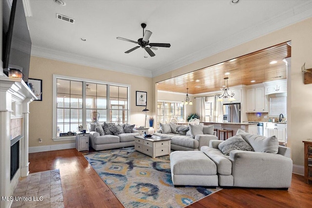 136 Mullherrin Dr, Madison, MS 39110 - living area with a ceiling fan, crown molding, a fireplace with flush hearth, visible vents, and wood finished floors