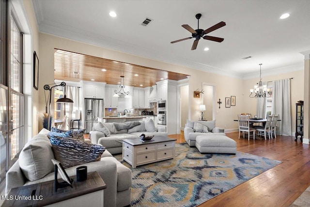 136 Mullherrin Dr, Madison, MS 39110 - living room featuring ornamental molding, recessed lighting, wood finished floors, and ceiling fan with notable chandelier