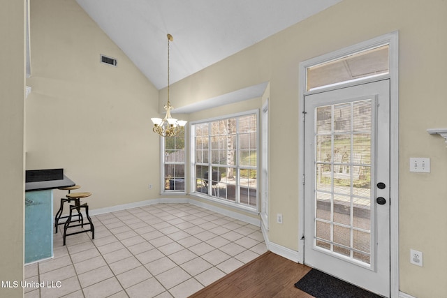 doorway with an inviting chandelier, baseboards, visible vents, and vaulted ceiling