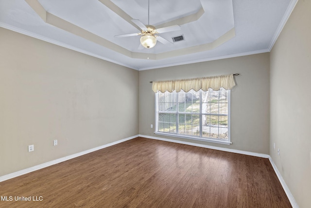 spare room featuring ceiling fan, dark wood-style flooring, a raised ceiling, and baseboards