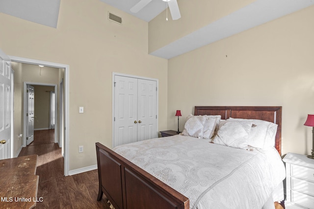 bedroom featuring ceiling fan, dark wood-style flooring, visible vents, baseboards, and a closet