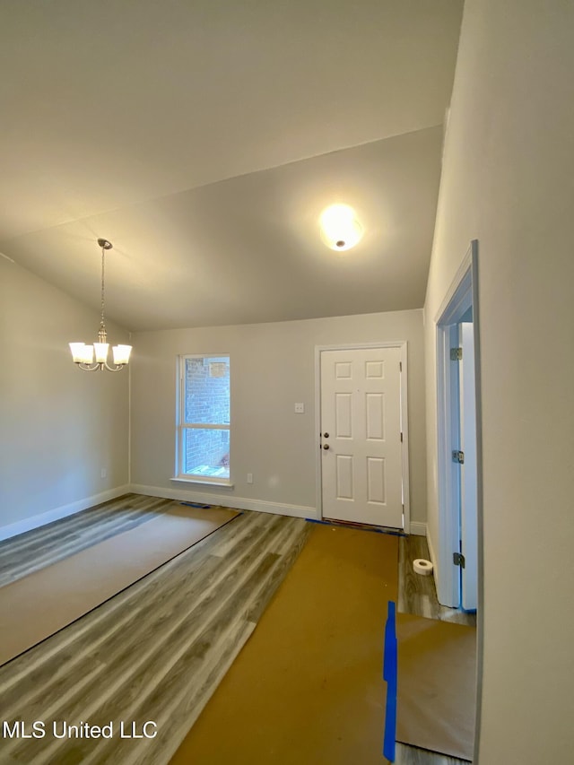 foyer featuring hardwood / wood-style floors, lofted ceiling, and an inviting chandelier