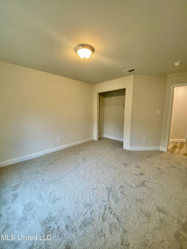 unfurnished bedroom with carpet floors and a closet