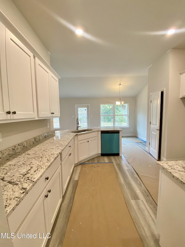 kitchen featuring stainless steel dishwasher, white cabinets, sink, and a chandelier