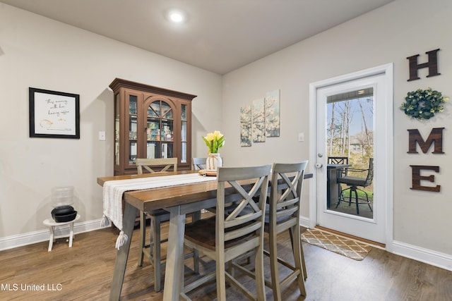 dining space featuring wood finished floors and baseboards