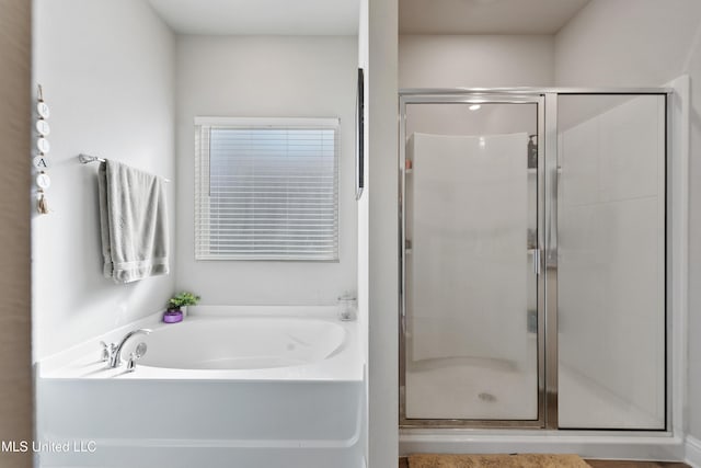 bathroom featuring a garden tub and a shower stall