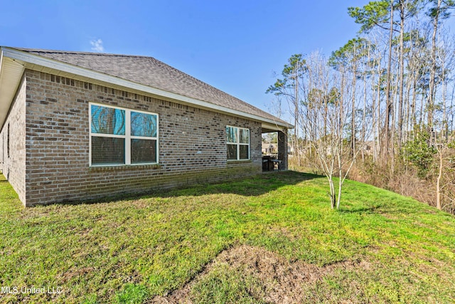 exterior space featuring brick siding and a lawn