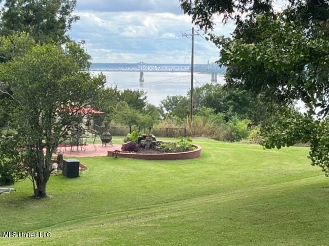 view of community with a water view and a lawn