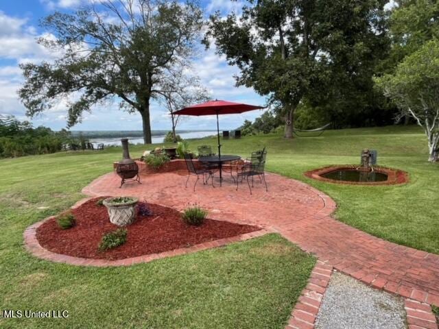 view of yard with a water view and a patio