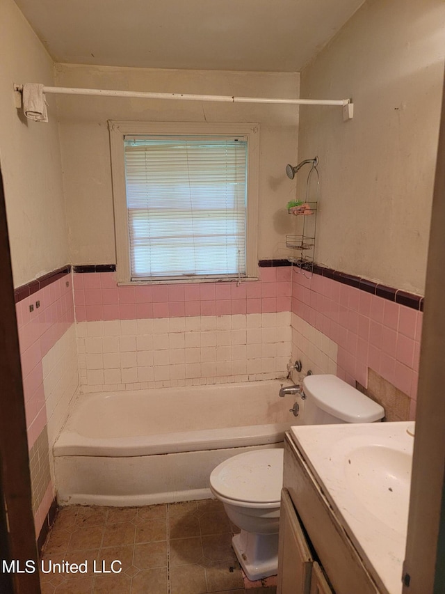 bathroom with vanity, toilet, tile patterned floors, and tile walls