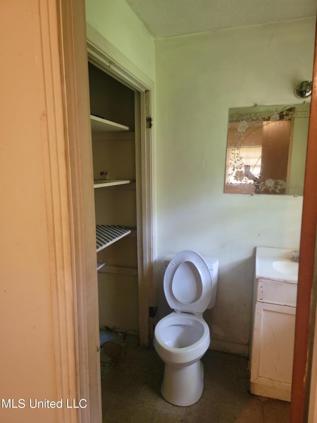 bathroom featuring vanity, toilet, and tile patterned flooring