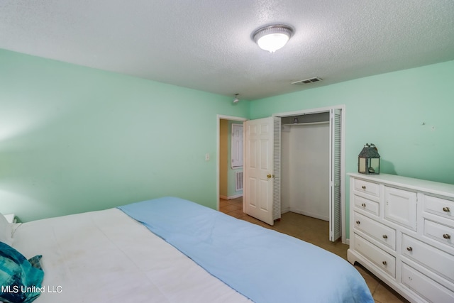 tiled bedroom featuring a closet and a textured ceiling