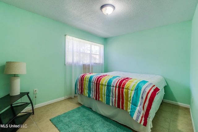 tiled bedroom with a textured ceiling