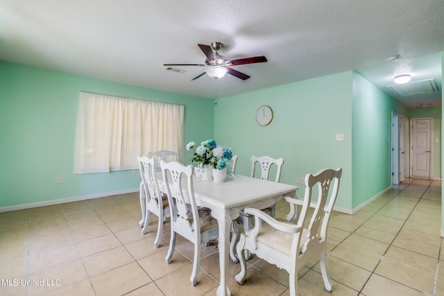 tiled dining area with a textured ceiling and ceiling fan