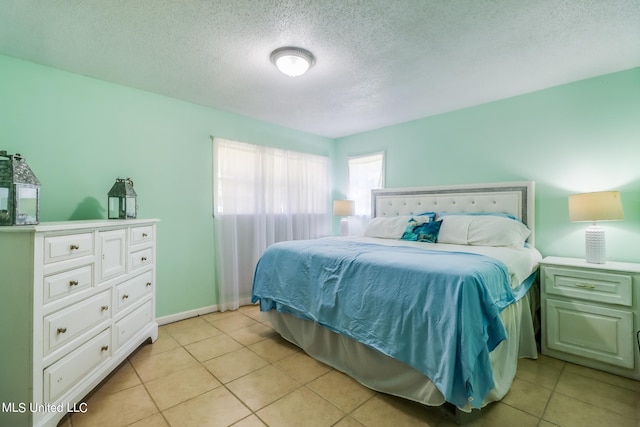 bedroom with a textured ceiling and light tile patterned floors