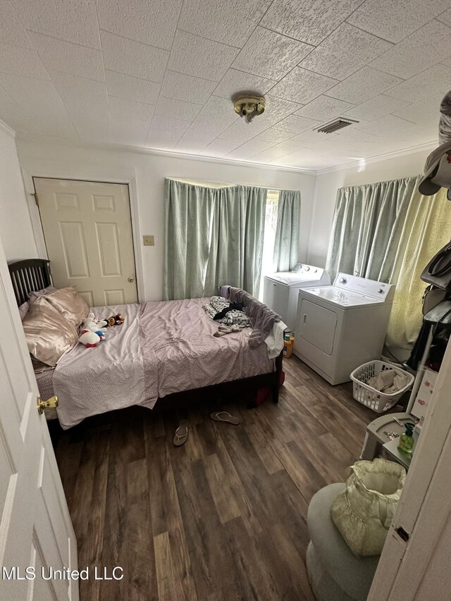 bedroom featuring visible vents, washer and clothes dryer, and wood finished floors
