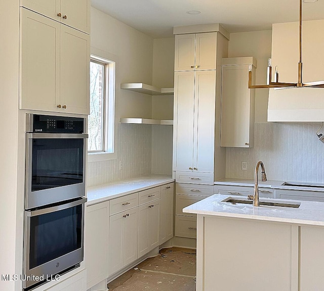 kitchen with light countertops, stainless steel double oven, a sink, and decorative backsplash