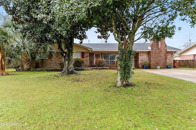 ranch-style home with brick siding, fence, concrete driveway, a front lawn, and a chimney